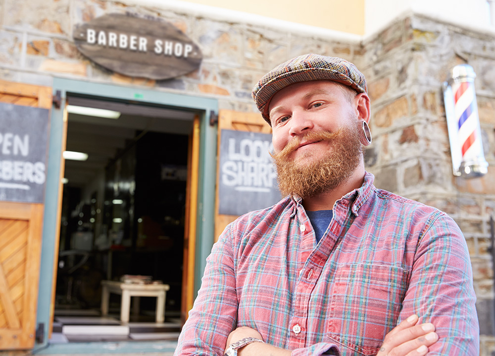 Barber Smiling in Front of Barber Shop