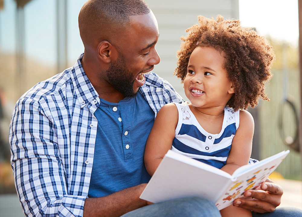 Young Black Father Reading to His Daughter