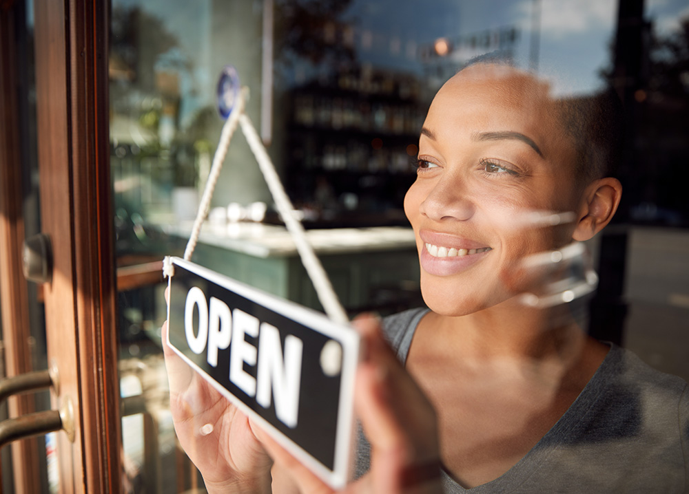 Female Business Owner Posting Open Sign