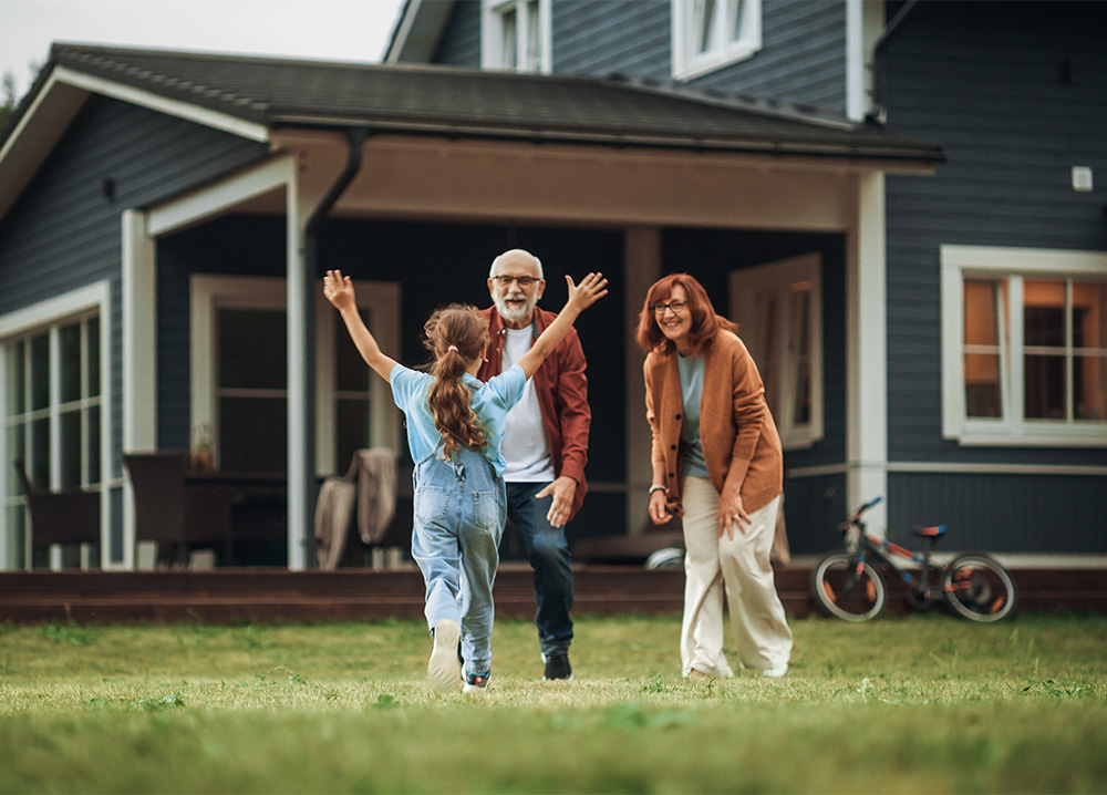 Grandparents Greeting Granddaughter Outside Home