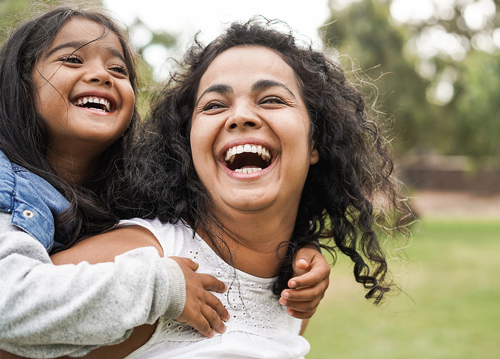 Mom Laughing with Young Daughter on Back