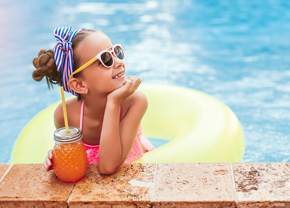 Little Girl Relaxing in Pool with Refreshing Drink