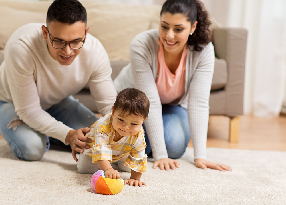 Young Parents Playing with Baby on Floor