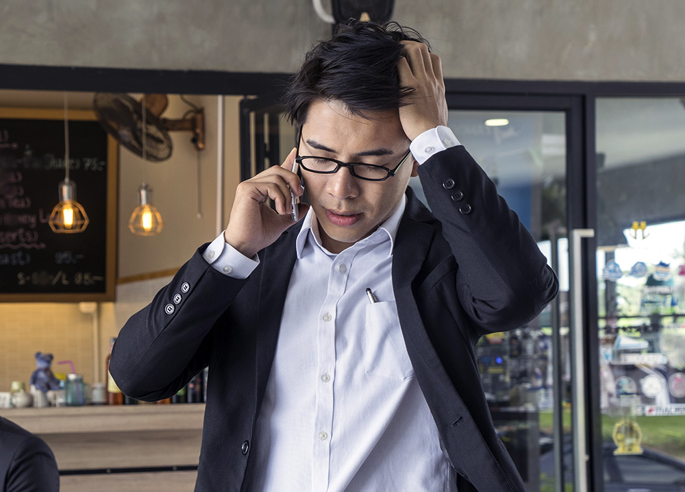 Young Asian Man Worried on Phone