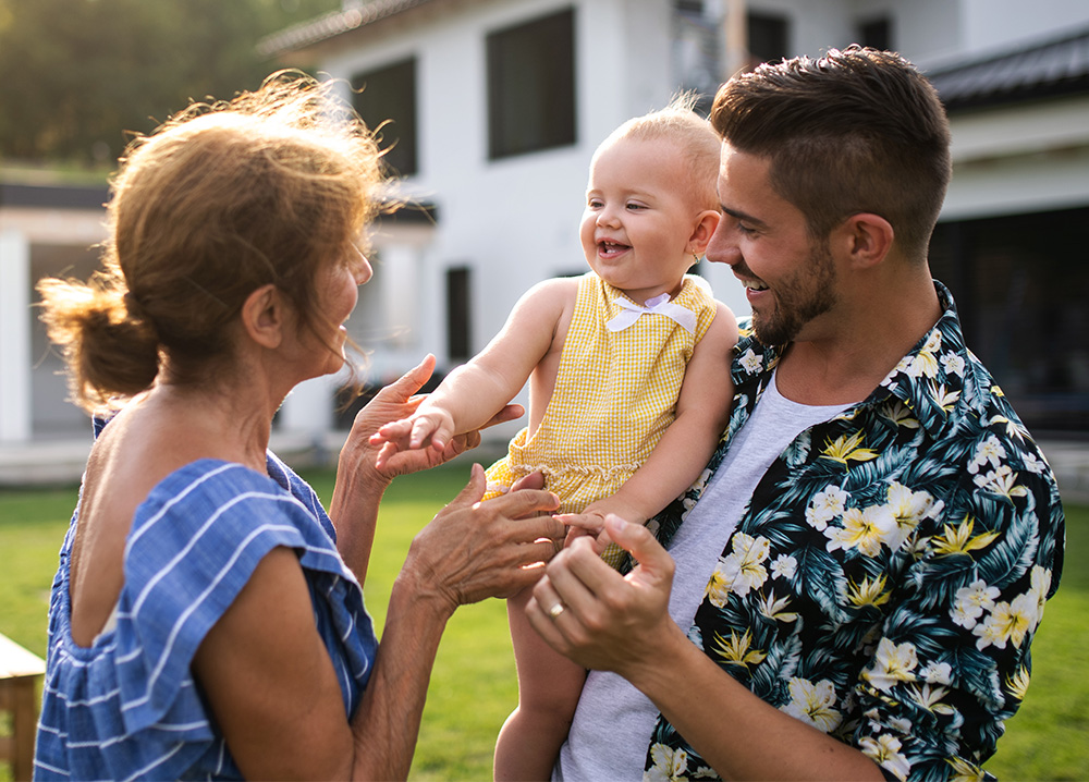 Grandmother Greeting Son and Granddaughter Outside Home